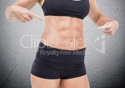 Mid section of fit woman pointing her abdomen