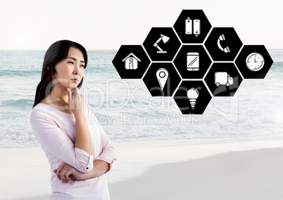 Thoughtful woman with application icons against beach in background