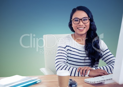 Smiling woman sitting at computer desk