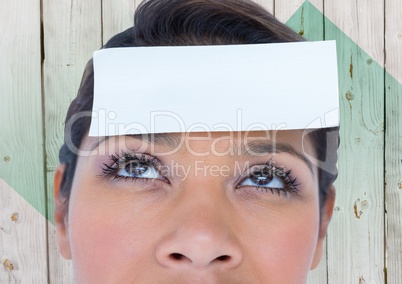 Woman with placard on forehead against wooden background