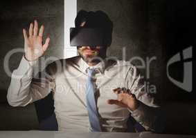 Man pretending to touch while wearing virtual reality headset
