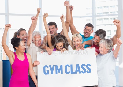Fit men and women holding placard with gym class text in fitness studio