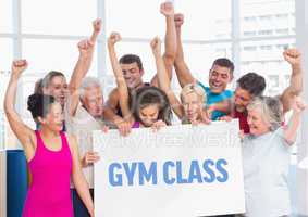 Fit men and women holding placard with gym class text in fitness studio