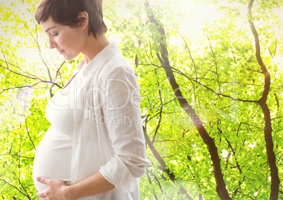 Smiling pregnant woman touching around the abdomen