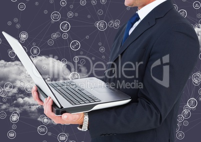 Businessman holding laptop with connecting icons and cloud in background