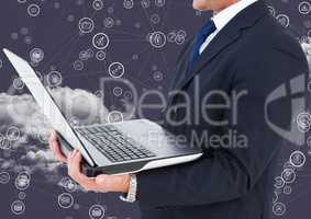 Businessman holding laptop with connecting icons and cloud in background