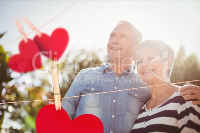 Red hanging hearts against senior couple in background