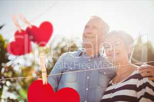 Red hanging hearts against senior couple in background