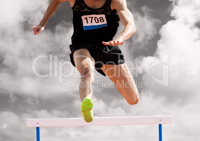 Athlete running over hurdle