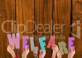 Hands holding word Welfare against wooden background