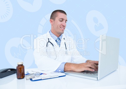 Smiling doctor using laptop at desk