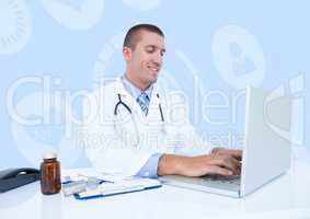 Smiling doctor using laptop at desk
