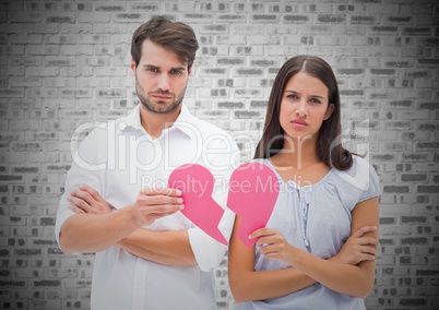 Worried couple holding a broken heart