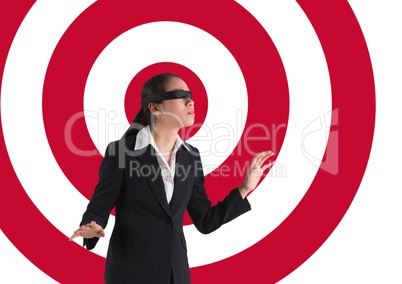 Conceptual image of businesswoman with black band on eyes against archery board
