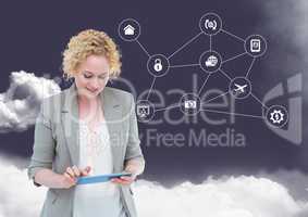 Businesswoman using digital tablet with networking icons and cloud in background