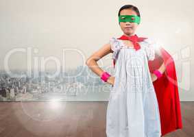 Portrait of super kid in red cape and green mask standing with hand on hip