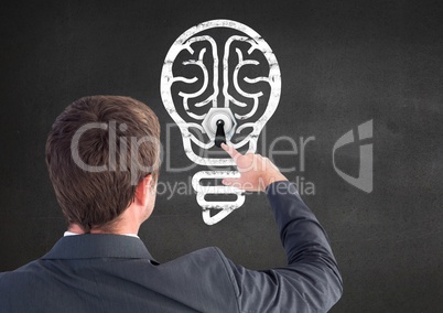 Rear view of businessman touching innovative bulb on grey background
