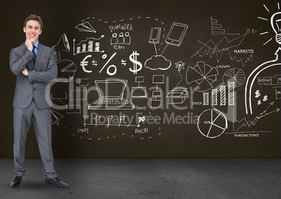 Thoughtful businessman standing against business symbols on blackboard