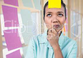 Blank sticky note on female executive forehead