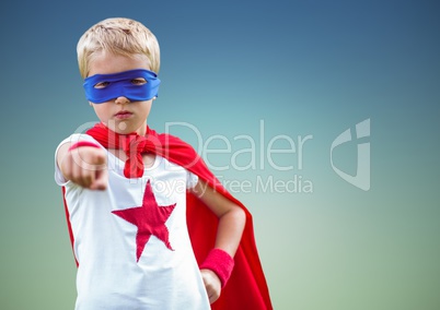 Boy pretending to be a superhero standing against sky blue background