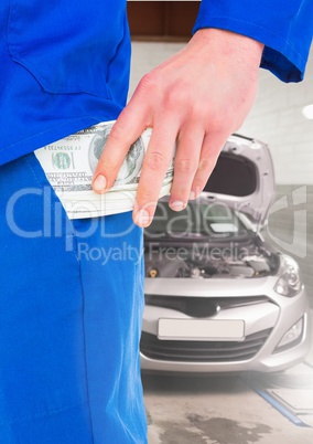 Mechanic keeping money in his pocket at garage