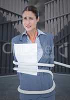 Portrait of tense businesswoman tied up with rope and paper