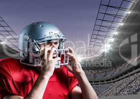 American football player removing his helmet against stadium in background