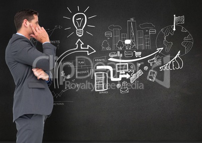 Businessman standing against business plan concept on blackboard