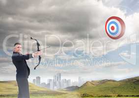 Businessman aiming at the target board against cityscape in background