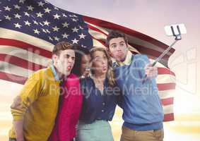 Friends taking selfie against american flag in background