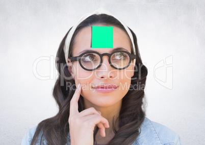 Thoughful woman with sticky note stuck on her forehead against white background