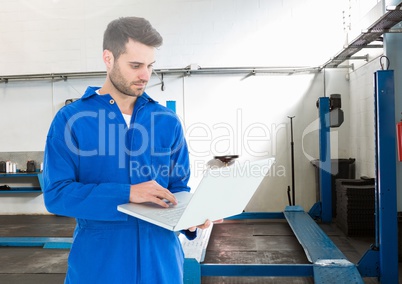 Automobile mechanic using laptop in workshop