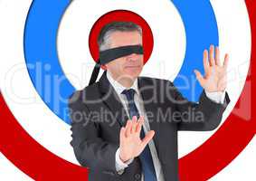 Conceptual image of businessman with black band on eyes against archery board