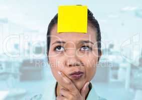 Thoughtful female executive with sticky note on head in office