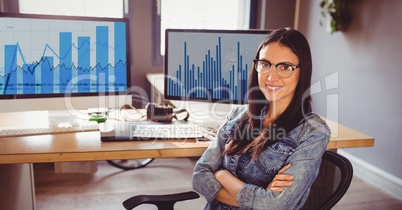 Businesswoman sitting with arms crossed at office