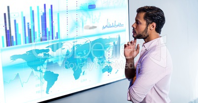 Thoughtful man with finger on chin looking at digital screen