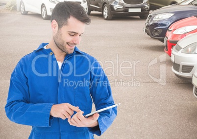 Smiling mechanic using digital tablet in parking area