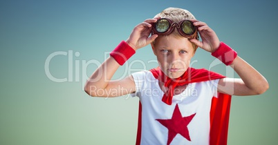 Confident boy wearing superhero costume standing against sky blue background