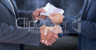 Businessmen shaking hands and receiving money
