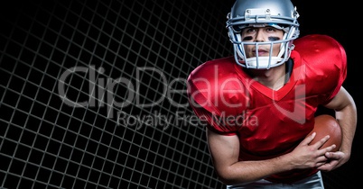 American football player playing against net on black background