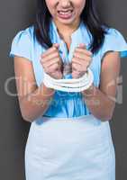 Businesswoman hands tied up with rope