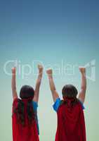 Kids in red cape and mask standing with fist against turquoise background