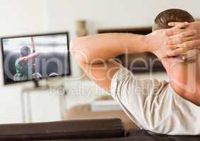 Rear view of man watching television in living room