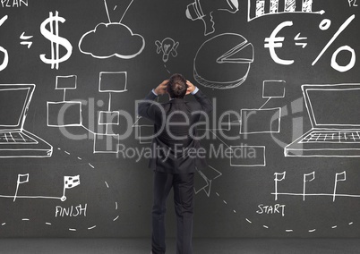 Rear view of businessman looking at graphics on wall