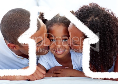 Parents kissing their daughter against house outline in background