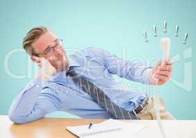 Irritated businessman holding telephone receiver at desk