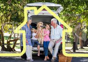 Happy family with pet dog overlaid with house enjoying picnic