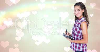 Portrait of smiling woman holding graphic tablet against heart background