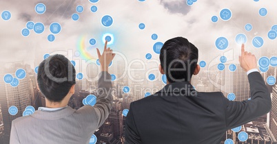 Business executives touching technology icons against cityscape