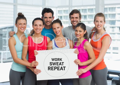 Group of people holding card with text  work, sweat and repeat in front of window in gym